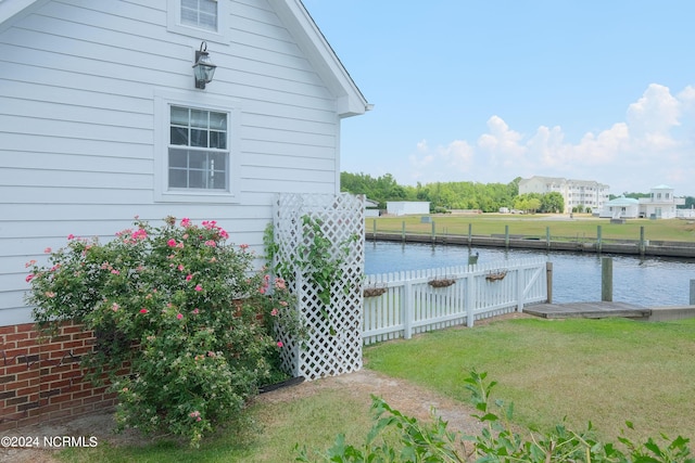 view of side of property featuring a water view and a yard