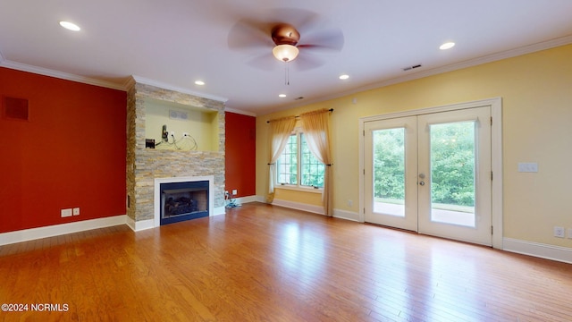 unfurnished living room with a fireplace, wood-type flooring, ceiling fan, and crown molding