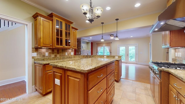 kitchen with french doors, decorative light fixtures, crown molding, and range hood