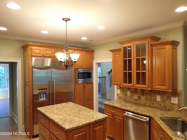 kitchen featuring pendant lighting, sink, appliances with stainless steel finishes, tasteful backsplash, and a chandelier