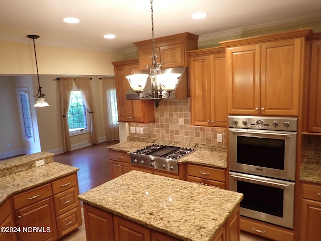 kitchen with a chandelier, crown molding, stainless steel appliances, and decorative light fixtures