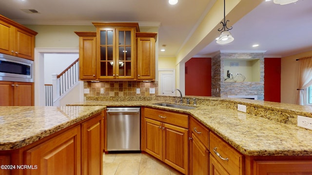 kitchen with pendant lighting, stainless steel appliances, ornamental molding, and sink