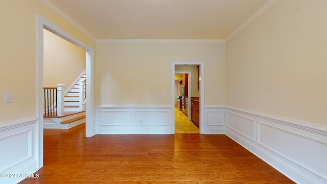 spare room featuring light hardwood / wood-style floors and crown molding