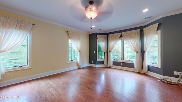 spare room featuring hardwood / wood-style floors, ceiling fan, and a healthy amount of sunlight