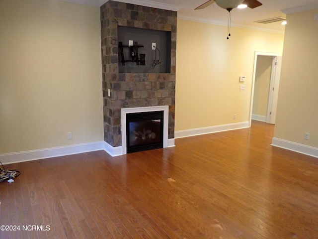 unfurnished living room featuring a fireplace, ceiling fan, wood-type flooring, and crown molding