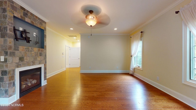 unfurnished living room with a fireplace, ceiling fan, wood-type flooring, and crown molding