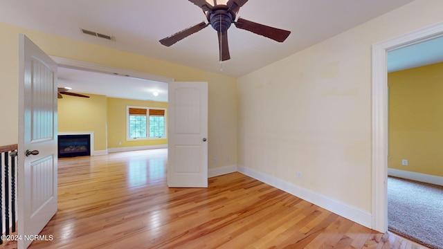 unfurnished room with light hardwood / wood-style flooring and ceiling fan