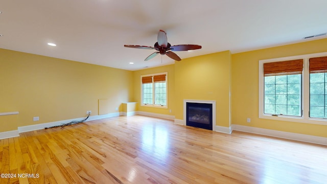 unfurnished living room featuring ceiling fan and light wood-type flooring