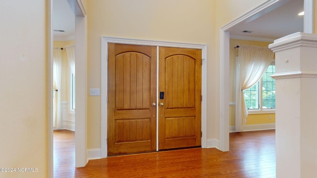 entrance foyer with ornamental molding and hardwood / wood-style flooring