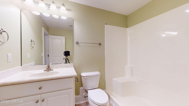 bathroom featuring vanity, toilet, and walk in shower