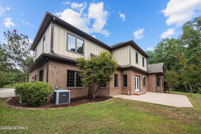 rear view of house with a lawn, a patio area, and central air condition unit