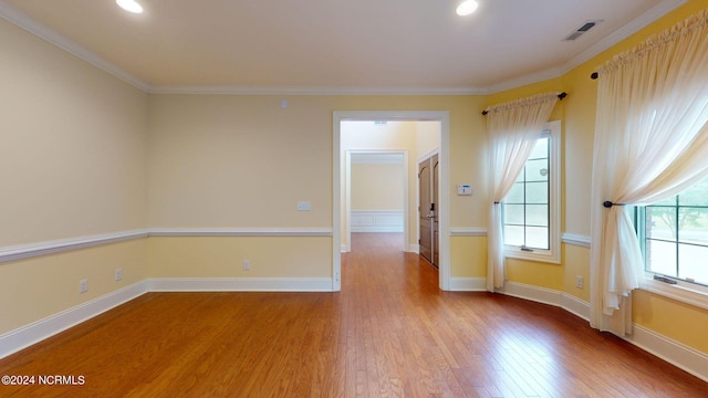 unfurnished room with light hardwood / wood-style floors and crown molding