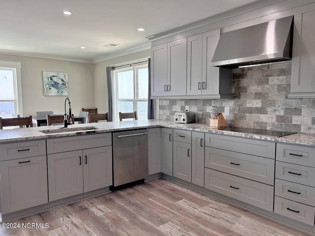 kitchen with black electric stovetop, light stone counters, a sink, wall chimney range hood, and dishwasher