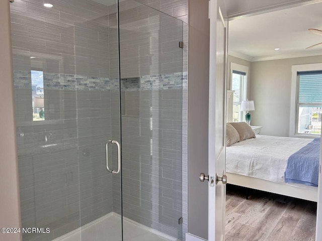 bathroom featuring wood finished floors, crown molding, a shower stall, and ensuite bathroom