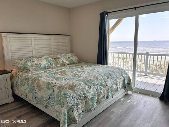 bedroom with a water view, access to outside, a view of the beach, and dark wood-type flooring