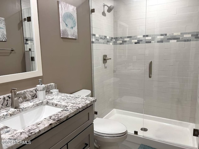 full bath with a shower stall, toilet, and vanity