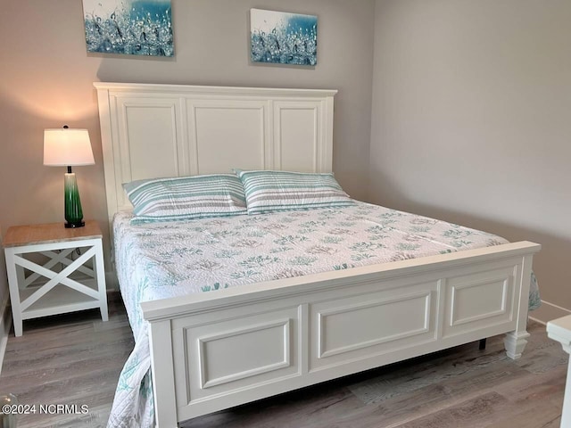 bedroom with baseboards and wood finished floors