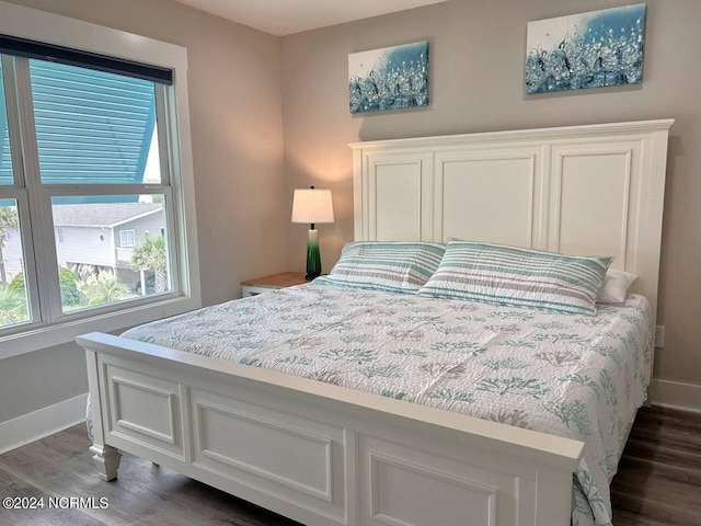 bedroom featuring dark wood-style floors and baseboards