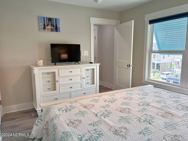 bedroom with wood finished floors and baseboards