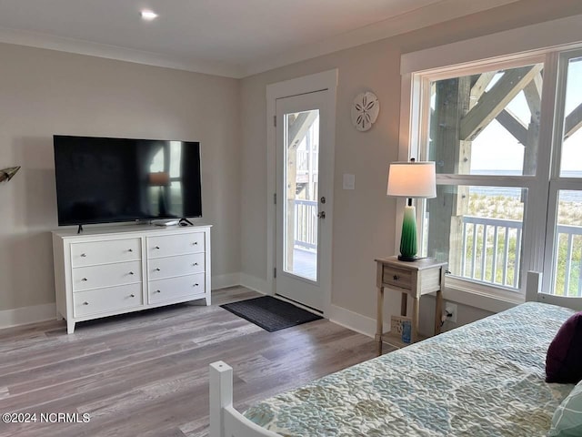 bedroom with light wood-type flooring, crown molding, and baseboards