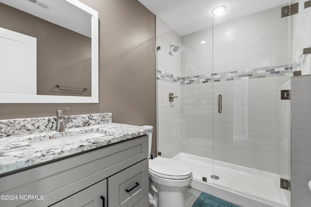 bathroom featuring toilet, a shower stall, visible vents, and vanity