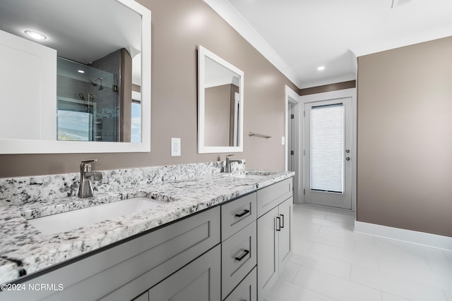 full bath featuring double vanity, crown molding, baseboards, and a sink