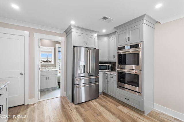 kitchen featuring light wood finished floors, visible vents, appliances with stainless steel finishes, light stone counters, and gray cabinetry