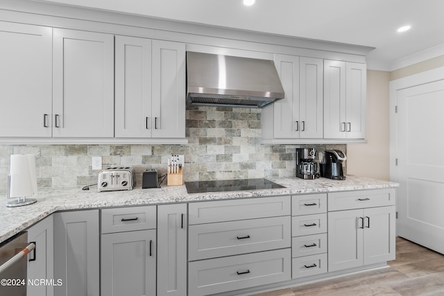 kitchen with light stone countertops, black electric cooktop, stainless steel dishwasher, wall chimney range hood, and backsplash