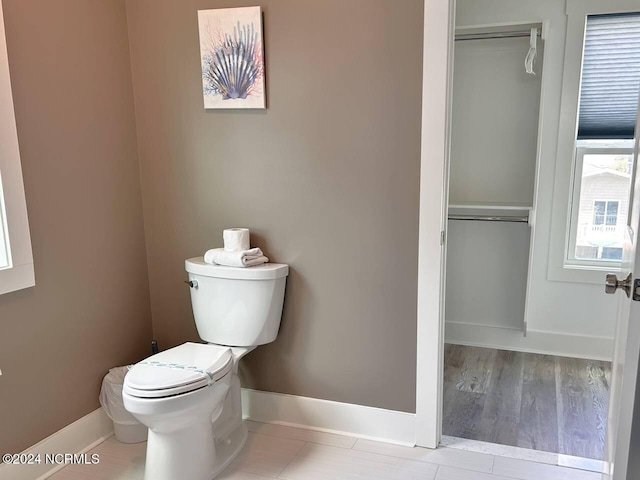 half bathroom with toilet and baseboards