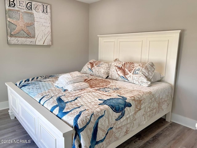 bedroom with dark wood-style floors and baseboards