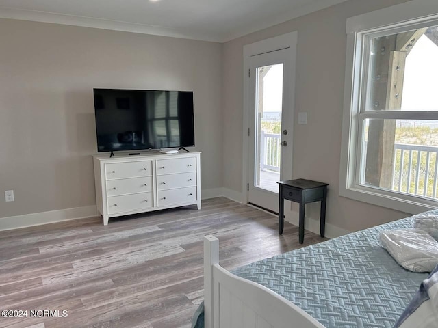 bedroom featuring crown molding, light wood finished floors, multiple windows, and baseboards