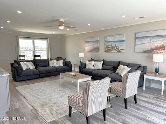 living area with light wood-style flooring, recessed lighting, visible vents, a ceiling fan, and ornamental molding