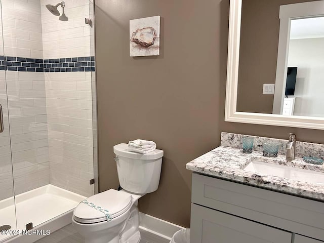 bathroom featuring toilet, a stall shower, and vanity