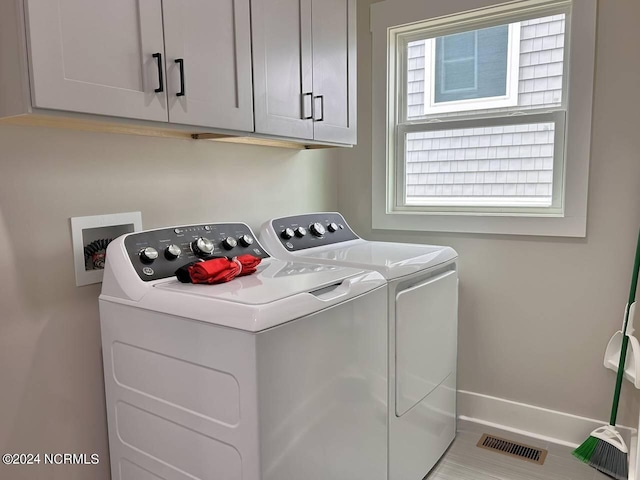 laundry room featuring cabinet space, washing machine and dryer, visible vents, and baseboards