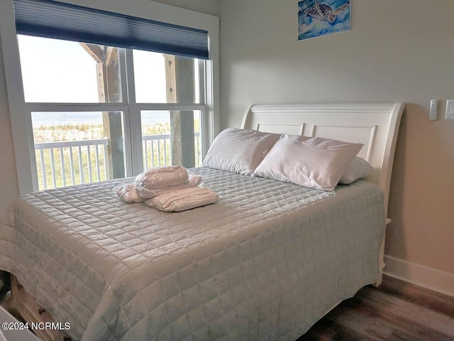 bedroom with baseboards and dark wood-type flooring