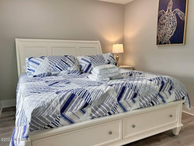 bedroom with dark wood finished floors and baseboards