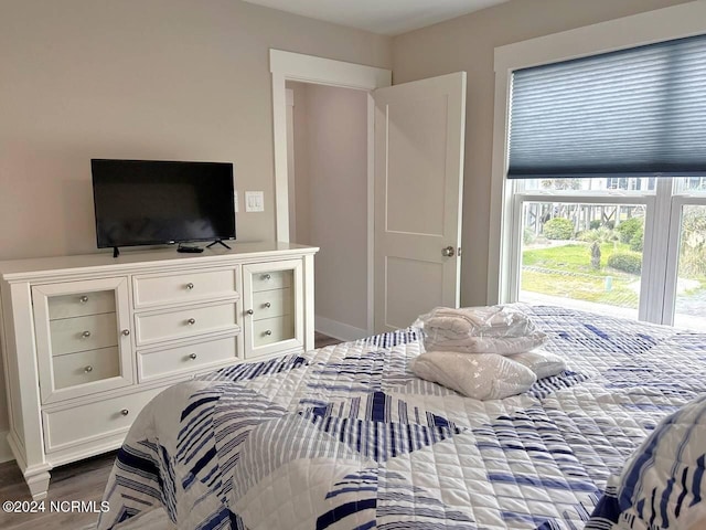 bedroom featuring access to outside and dark wood finished floors