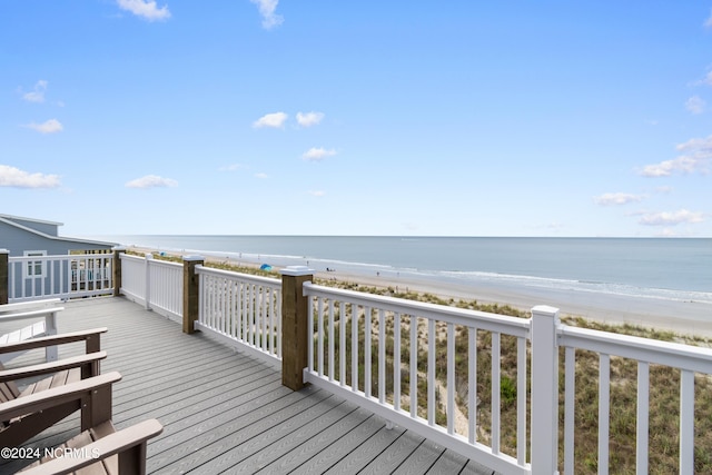 wooden terrace with a water view and a view of the beach