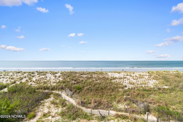 property view of water featuring fence and a view of the beach