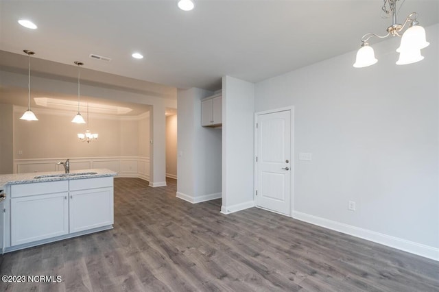 kitchen featuring white cabinetry, hanging light fixtures, sink, and a chandelier