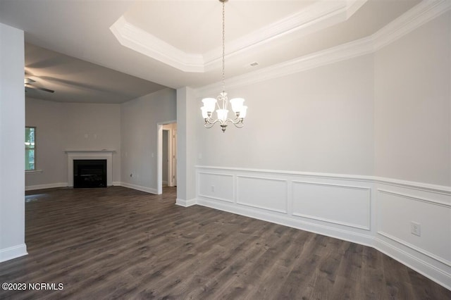 unfurnished dining area with dark hardwood / wood-style floors, a raised ceiling, and a notable chandelier