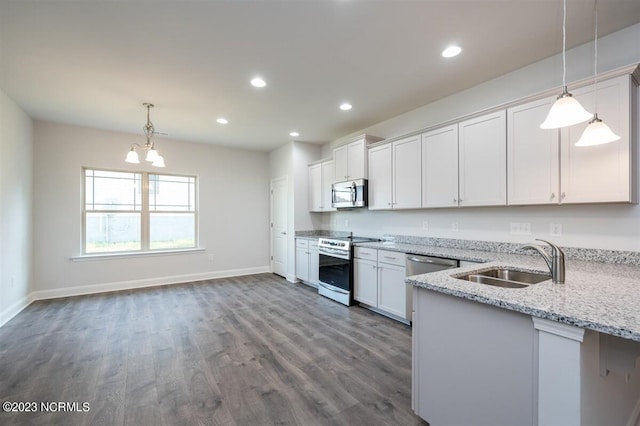 kitchen with stainless steel appliances, white cabinetry, hanging light fixtures, and sink