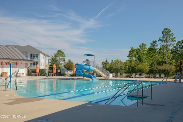 view of pool featuring a water slide and a patio area