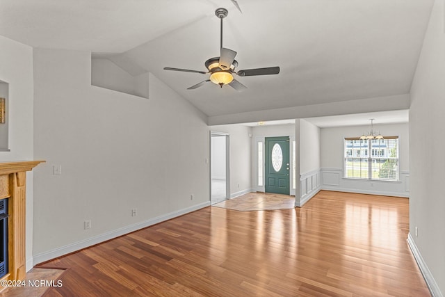 unfurnished living room with lofted ceiling, ceiling fan with notable chandelier, and light hardwood / wood-style flooring