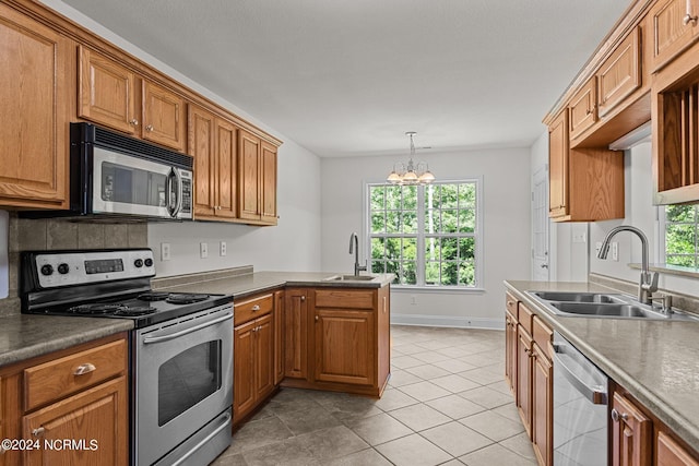 kitchen with pendant lighting, stainless steel appliances, light tile patterned flooring, and sink