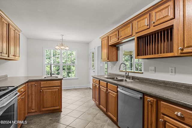 kitchen with light tile patterned flooring, appliances with stainless steel finishes, sink, a chandelier, and hanging light fixtures