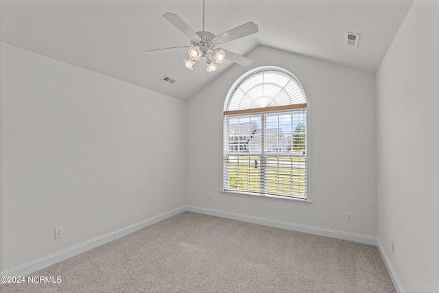 spare room with ceiling fan, lofted ceiling, and light carpet