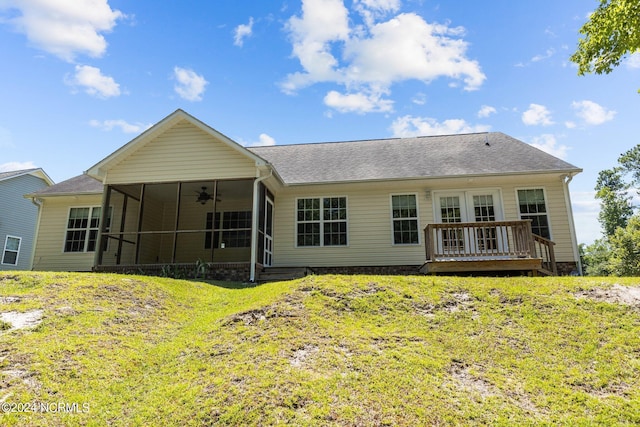 back of property featuring ceiling fan, a deck, a sunroom, and a lawn