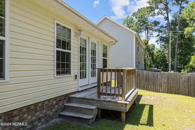 wooden terrace with a lawn and french doors