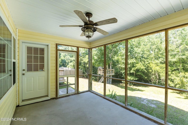 unfurnished sunroom with ceiling fan